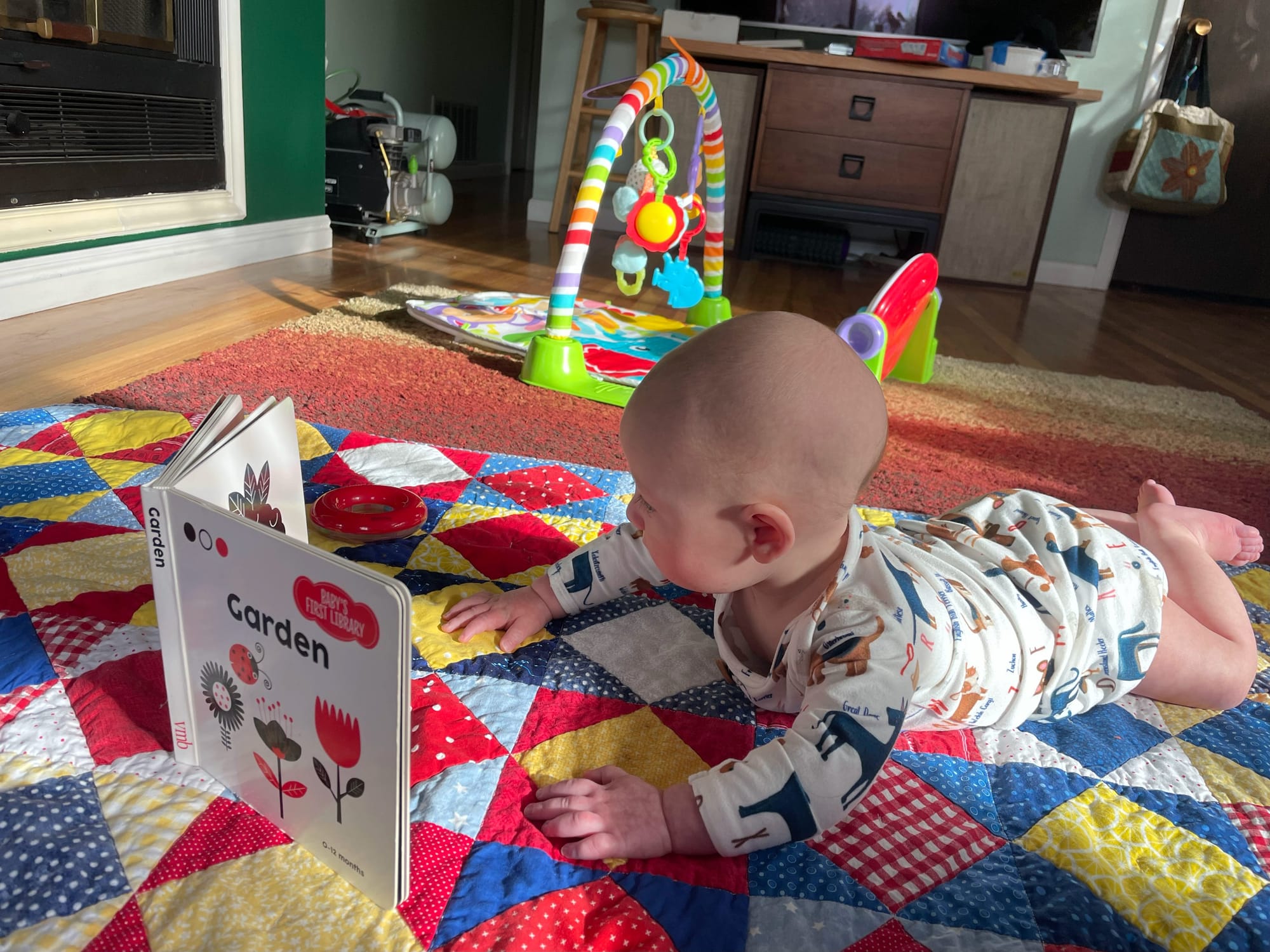 Baby around four and a half months reaching for a toy during tummy time