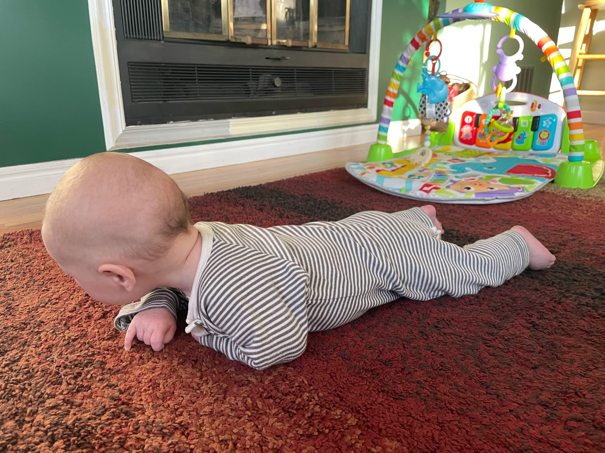 Three-month-old baby pushing up on forearms during tummy time